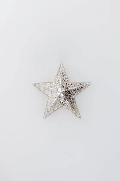 Gümüş Noel yıldızı beyaz bir sıvının içinde yüzüyor. Minimum düzlük.