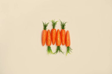 Bej arka planda havuçtan yapılmış yaratıcı bir kavram. Yaratıcı Paskalya kartı fikri. Boşluğu kopyala.