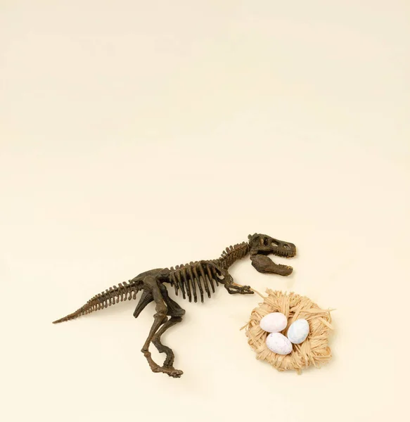 T-Rex ve yumurtalar bir yuvada. Bej arka planda dinazor Paskalya Dünyası.