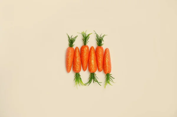 Bej arka planda havuçtan yapılmış yaratıcı bir kavram. Yaratıcı Paskalya kartı fikri. Boşluğu kopyala.