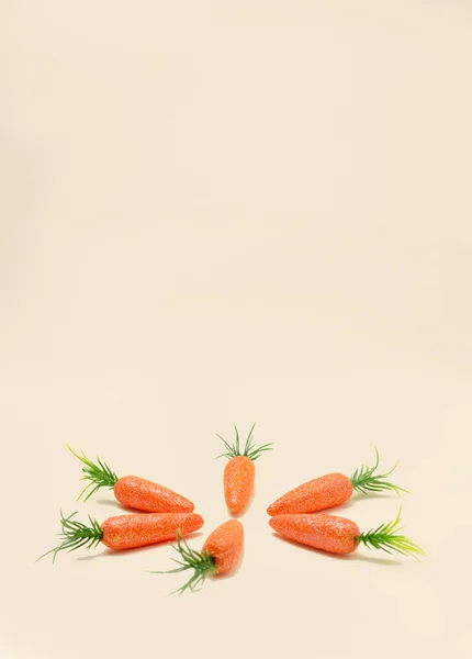 Bej arka planda turuncu havuçlar. Yaratıcı Paskalya kartı fikri.