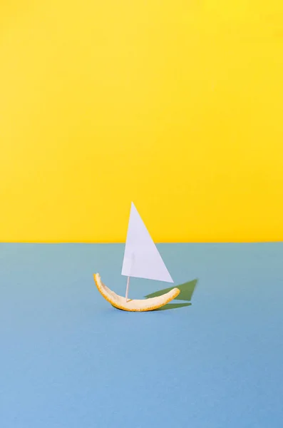 Yelkenlinin yaratıcı düzenlemesi mavi ve sarı arka planda portakal kabuğundan yapılmış. Asgari yaz fikri.