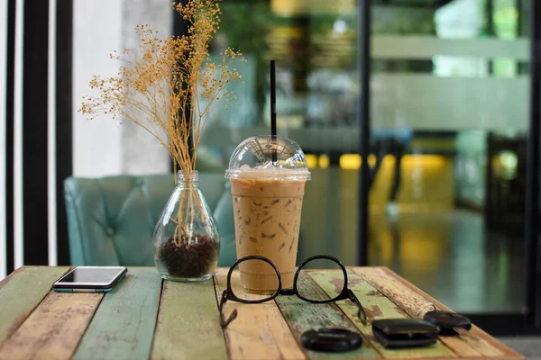 Kahve dükkanındaki ahşap masada buzlu kahve. Süt ve kurabiyelerle dolu.