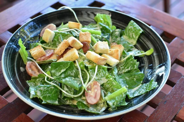 Sezar salatası marul, tavuk ve kruton ahşap tablo.