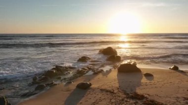 Kum ve kayalar ve arka planda Atlantik denizi