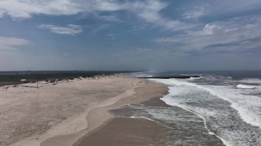 Portekiz sahilinde büyük kum tepeleri olan kocaman boş bir sahil.