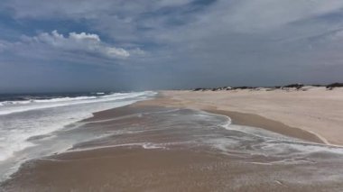 Portekiz sahilinde büyük kum tepeleri olan kocaman boş bir sahil.
