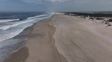 Portekiz sahilinde büyük kum tepeleri olan kocaman boş bir sahil.