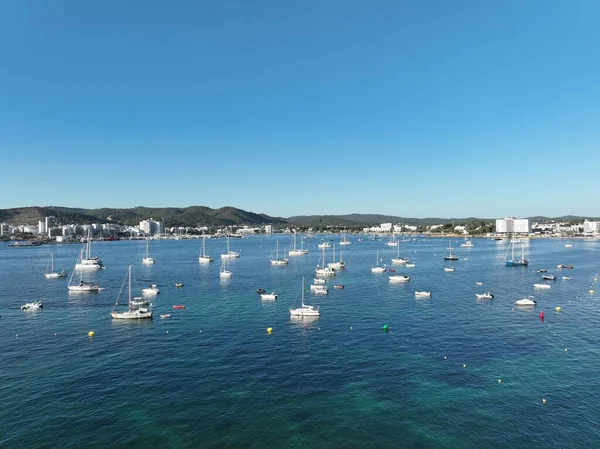 Sahile demir atmış tekne ve teknelerle dolu bir adanın hava manzarası. İbiza.