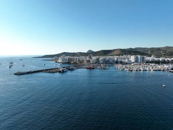 Sahile demir atmış tekne ve teknelerle dolu bir adanın hava manzarası. İbiza.