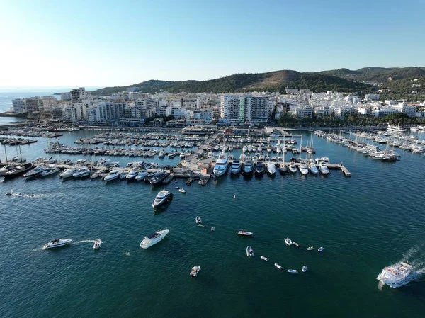 Yat limanında tekne ve yelkenli dolu dubaların havadan görünüşü şehre bakıyor. İbiza,