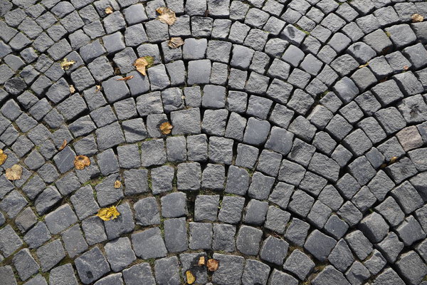 A fragment of the paving of the street with roughly processed granite cobblestones in close-up
