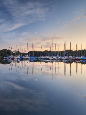 Düsseldorf, Almanya - Unterbacher Gölü 'nde huzurlu bir akşam. Limanda demirli yelkenliler. Gün batımından sonraki güzel manzara.