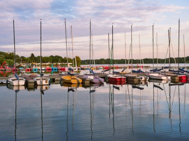 Düsseldorf, Almanya - Unterbacher Gölü 'nde huzurlu bir akşam. Limanda demirli yelkenliler. Güneş batmadan önce güzel manzara.