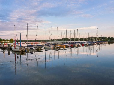 Düsseldorf, Almanya - Unterbachersee Gölü 'nde huzurlu bir akşam. Limanda demirli yelkenliler. Güneş batmadan önce güzel manzara.
