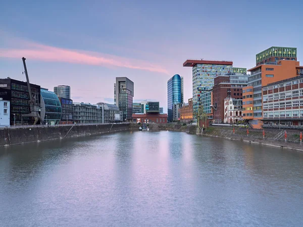 Düsseldorf, Almanya - Şafakta güzel aydınlatılmış Medienhafen. Mavi saatte şehir manzarası..