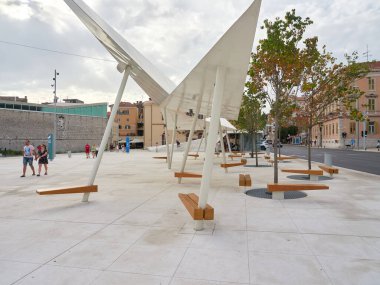 Sibenik, Hırvatistan - 26 Temmuz 2021: Modern banklarla şehir kütüphanesinin önündeki meydan.