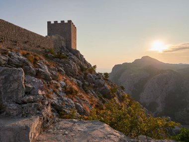 Günbatımında Omis kasabasındaki Starigrad kalesi.
