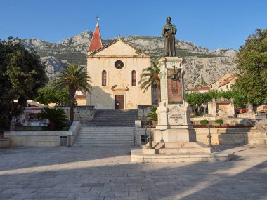 Makarska, Dalmaçya, Hırvatistan - 20 Temmuz 2021: St. Mark Katedrali ve eski kentte Andrija Kaciç Miosiç 'in heykeli. Arka planda Biokovo 'nun sıradağları.