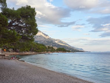 Brela, Dalmaçya, Hırvatistan - 19 Temmuz 2021: Punta Rata plajı. Biokovo dağ sırası ve Adriyatik Denizi manzarası.