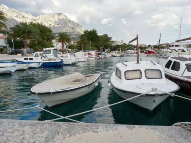 Baska Voda, Dalmaçya, Hırvatistan - 19 Temmuz 2021: Şehrin üzerinde gökkuşağı. Gezinti güvertesi, marina ve Biokovo Dağları manzarası.