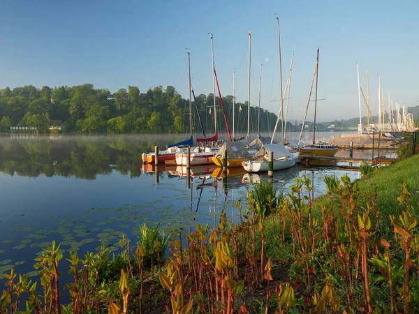 Essen şehrinde, Baldeneysee Gölü üzerinde harika bir gündoğumu. Ön planda demirli yelkenliler. Peyzaj fotoğrafçılığı
