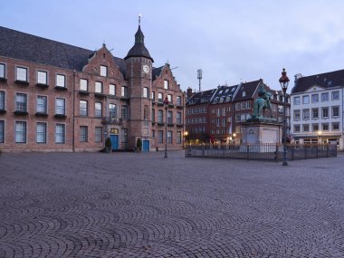 Almanya 'nın eski Düsseldorf kasabasındaki belediye binası. Johann Wilhelm 'in heykelinin olduğu merkez meydan şafakta..