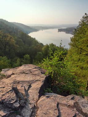 Essen şehrinin Ruhr Nehri üzerindeki Baldeneysee Gölü 'nün bahar manzarası. Gölün tepesinden sabah manzarası çiçek açan yeşil ağaçlarla çevrili..