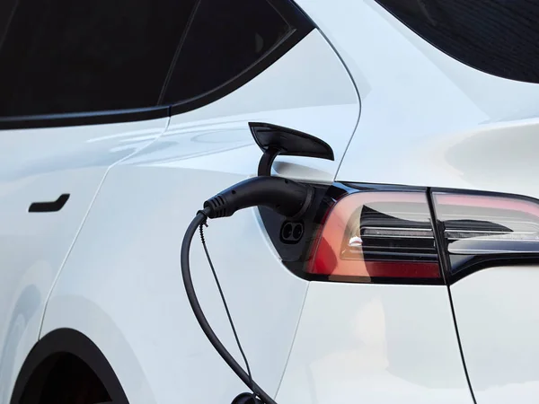 Charging an electric car from a household socket. Close up of the charger plug.