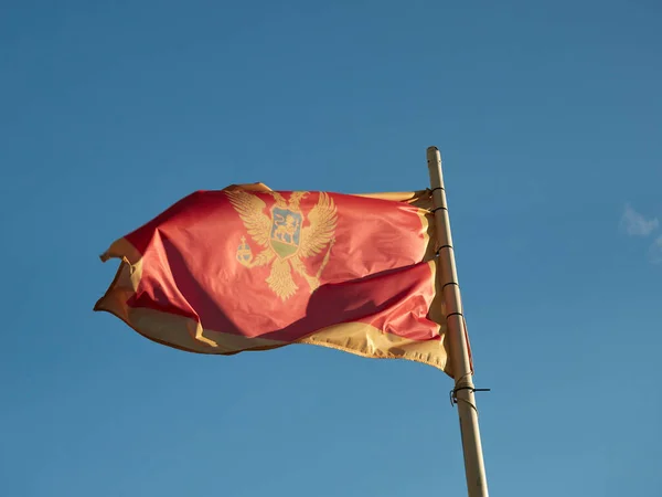 Montenegrin Flag Hung Mast Fluttering Wind Backdrop Blue Sky — Zdjęcie stockowe