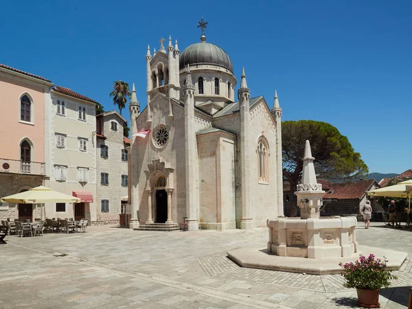 Herceg Novi, Montenegro, July 16, 2022: The Church of Saint Michael the Archangel and the fountain in Belavista Square in the old town.