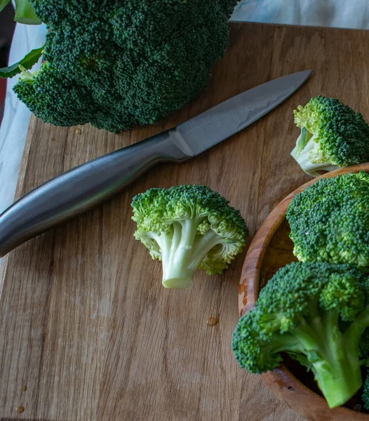 pieces of broccoli on a wooden board , close - up