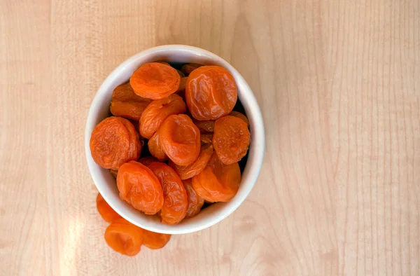 dried apricots on a white plate, top view, on a light background