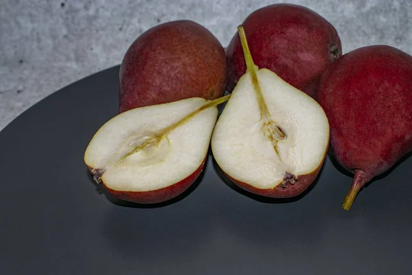 pears on a dark plate close-up, red pears