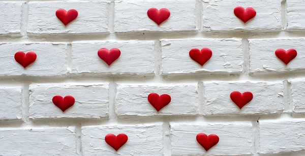lots of little hearts on a white brick wall background