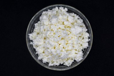 Yuvarlak bir kasede süzme peynir, koyu arkaplan, üst manzara, merkez konum