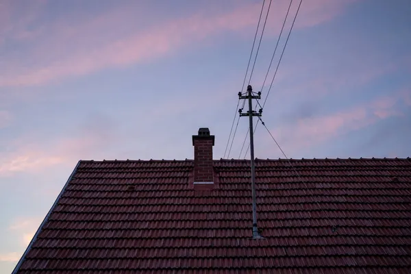 蓝色的夜空 粉色的云彩笼罩着房子的屋顶 — 图库照片