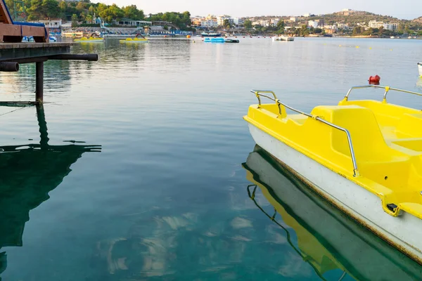 蓝色海面上的黄色踏板船 背景是船 酒店和小山 — 图库照片