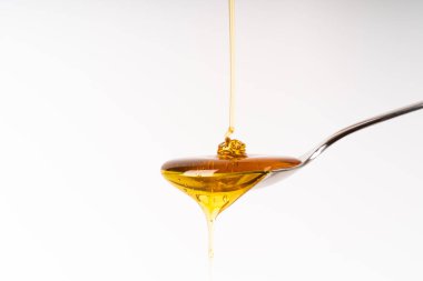 Altın renkli organik bal taşana kadar kaşıkta akar.