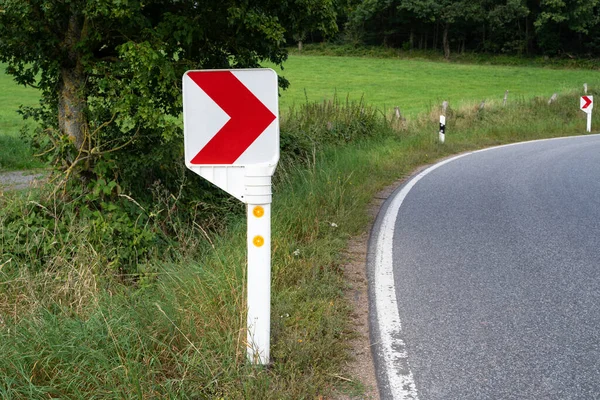 Keskin bir virajda sağa bakan kırmızı bir okla yol işareti