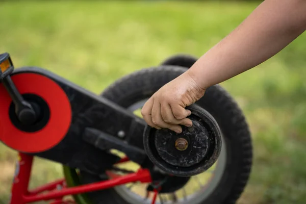 Menino Segura Roda Treinamento Sua Bicicleta Com Uma Mão Suja — Fotografia de Stock