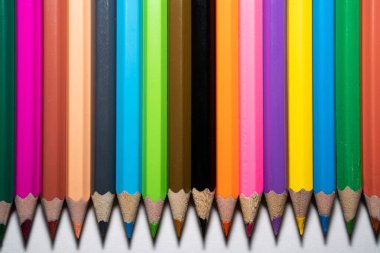 üst üste beyaz bir arka plan üzerinde renkli kalemler