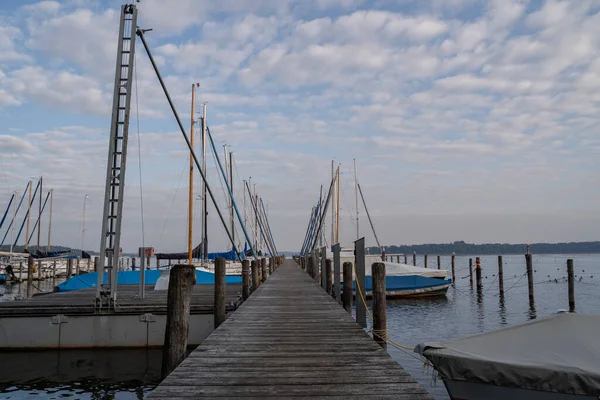 湖の木製の桟橋の上でロープで覆われた帆船 — ストック写真