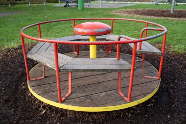 Round red and yellow carousel for children in the playground