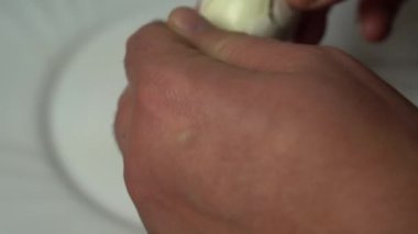 İnsan, kaynamış yumurtayı beyaz bir tabakta soyar.