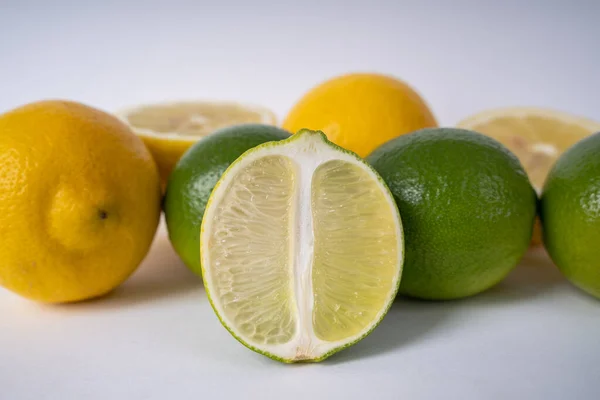 Half and whole lemon and lime fruits on a white background