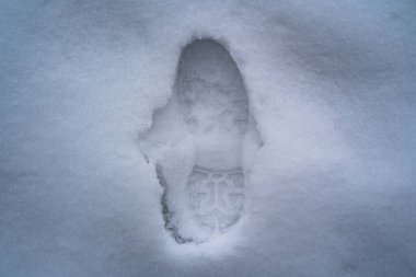 Koyu beyaz karda yürüyüş ayakkabısının izi.