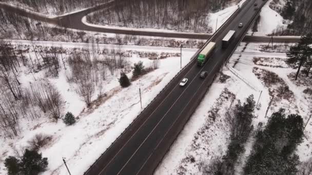 Highway με φορτηγά και αυτοκίνητα που ταξιδεύουν πάνω από τη γέφυρα το χειμώνα, εναέρια άποψη. — Αρχείο Βίντεο