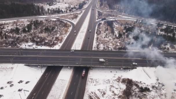 Landweg met rotonde en autobrug in de winter, luchtfoto. — Stockvideo