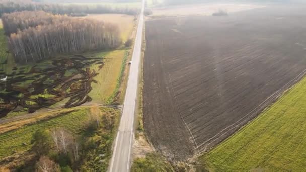 País estrada estreita ao lado de campos agrícolas aráveis, vista aérea. — Vídeo de Stock